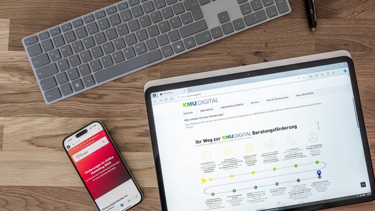 Laptop und Handy zeigen Screenshots der Websites kmu.digital und irretio.at
