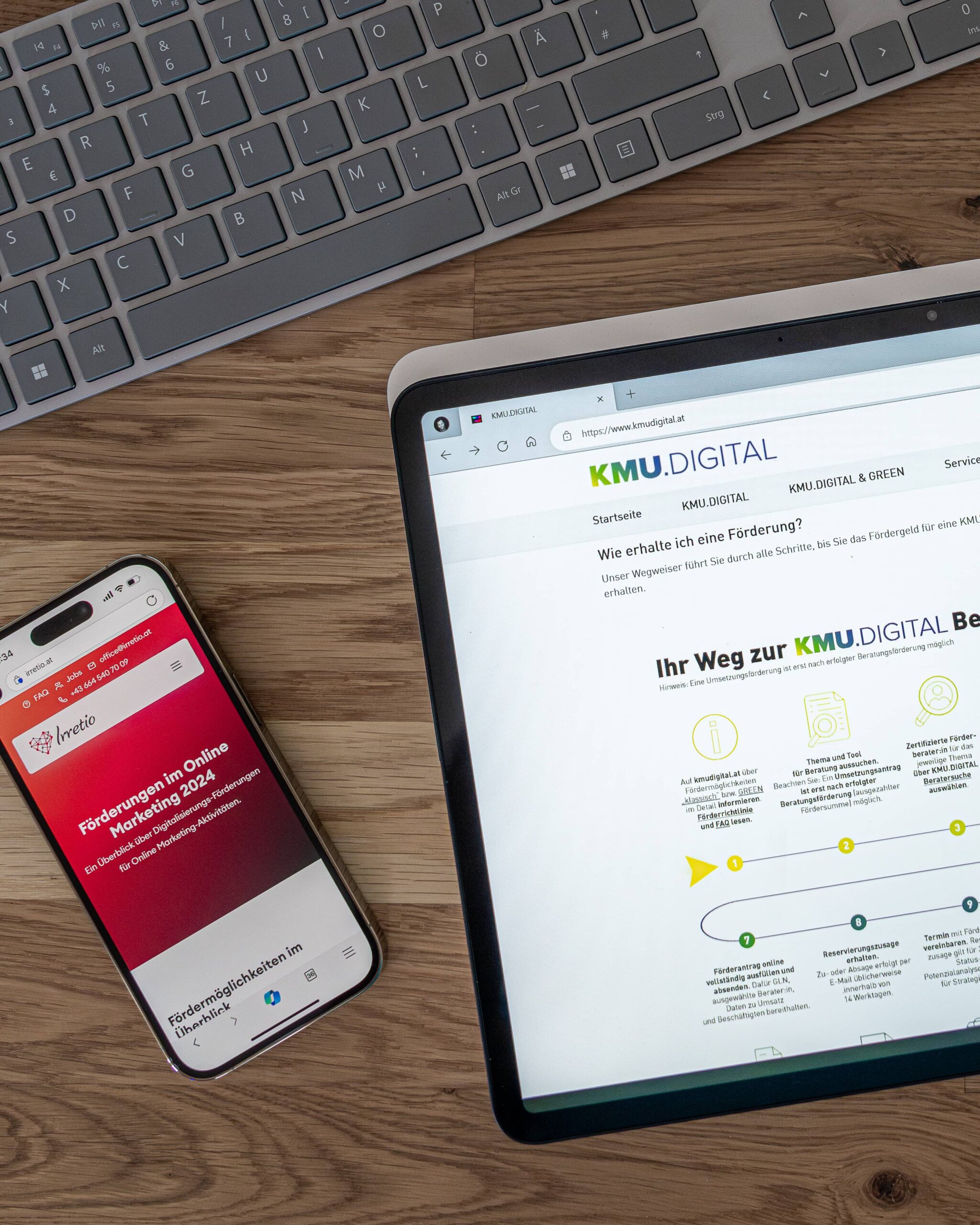 Laptop und Handy zeigen Screenshots der Websites kmu.digital und irretio.at