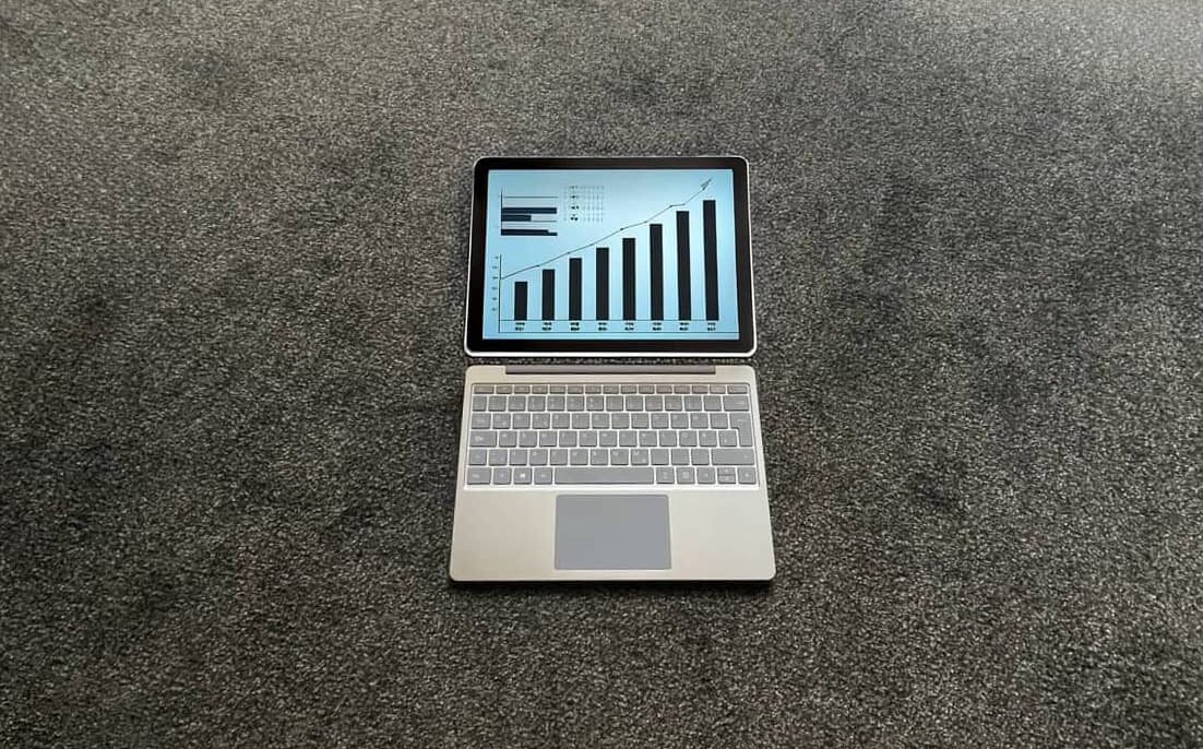 Laptop am Boden zeigt steigende Graphen
